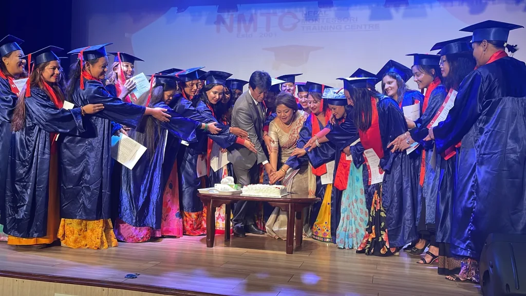 NMTC graduates in caps and gowns receiving their certificates on stage