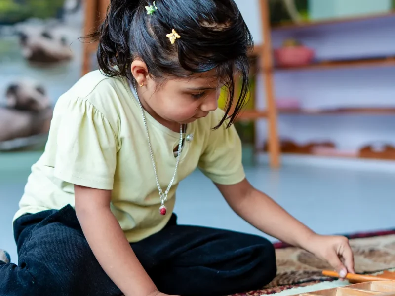 Girl working with wooden rods from a box