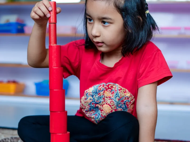 Girl building the pink tower