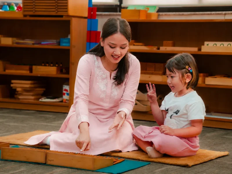 Teacher and child laughing together during a lesson