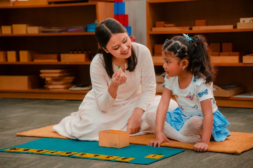Teacher showing a child a small object from a wooden box
